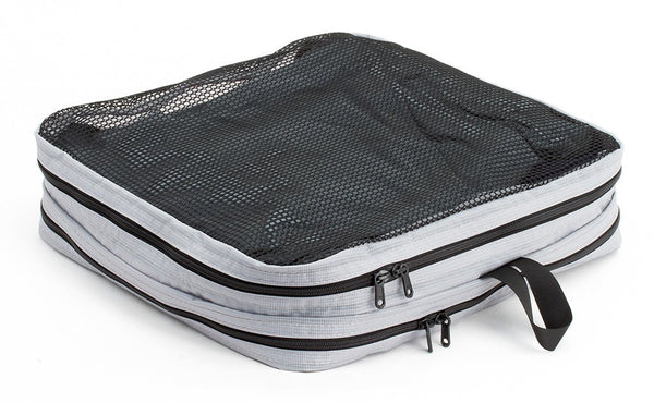 A filled and zipped closed Northwest Sky (light grey) Aether Large Laundry Aeronaut 30 Packing Cube mesh side up.
